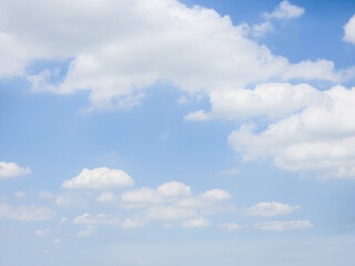 Fototapeta premium A wide angle view of a blue sky with scattered white cumulus clouds across the horizon.