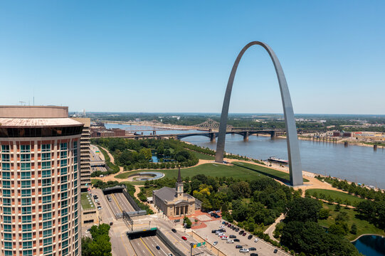 Aerial view of the Gateway Arch on the Mississippi River banks, with the Old Cathedral, urban architecture, and bridges in St. Louis, Missouri, United States.