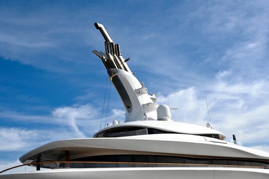 large, white expensive luxury yacht top in closeup view on the Adriatic sea. travel, tourism, summer, vacation and leisure concept. stainless steel chimneys., curved boat body. modern design. blue sky