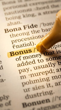Close-up of a dictionary page with the word "Bonus" highlighted with a yellow marker, symbolizing extra gain or reward in business or personal finance