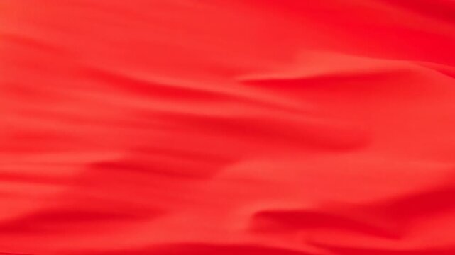 Red satin fabric unfolding into wide smooth waves under soft diffuse light for branding backdrops