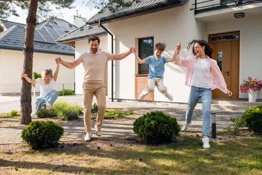 Happy family jumping in front of new house
