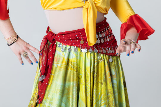 Gypsy dancer hands and colourful costume with coin scarf close up on white background