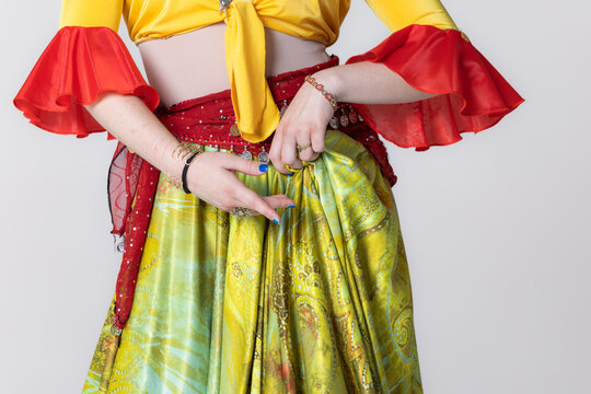 Gypsy dancer hands and colourful costume with coin scarf close up on white background
