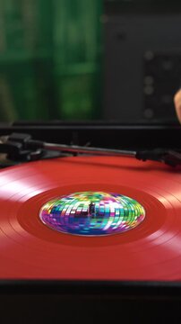 Vertical View of Red Vinyl Record, Placing dn Starting Playback on Turntable in Room Ambience