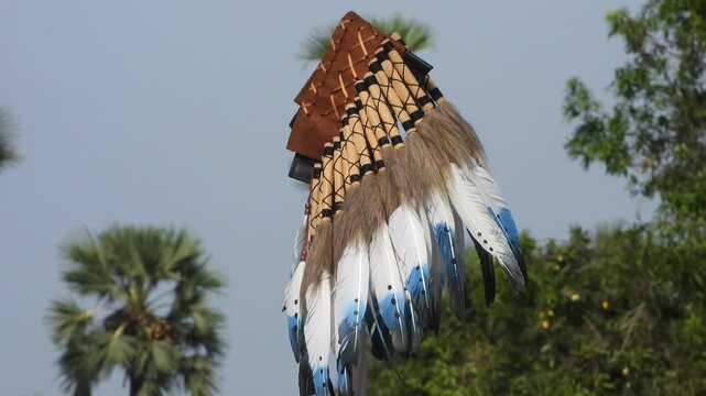 A Native American headdress hanging on stick .