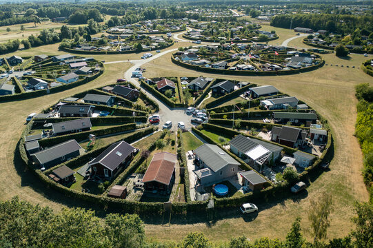 Aerial view of Brondby Garden City with circular garden allotments and small houses arranged in a radial pattern surrounded by green hedges in Denmark.