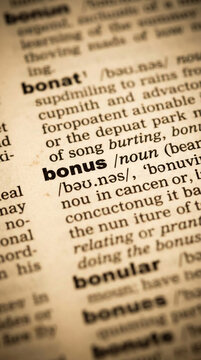 Close-up of a dictionary page with the word "bonus" highlighted, symbolizing financial gain and additional benefit