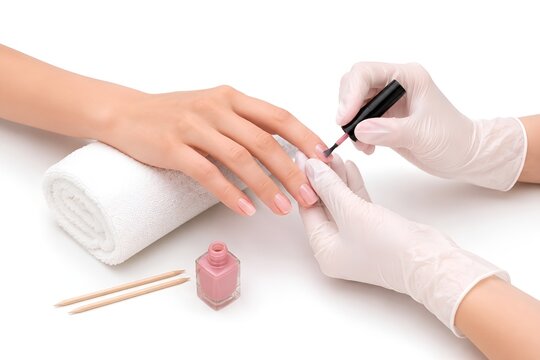 Professional manicure service applying pink nail polish on fingernails