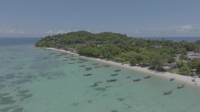 Aerial drone view of Koh Lipe island, Satun, Thailand. Turquoise sea, coral reefs, white sand beaches and traditional long-tail boats in the Andaman Sea.