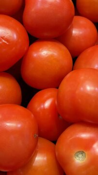 Fresh ripe tomatoes stacked closely, ideal for food background or healthy eating concepts