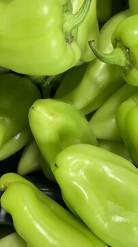 Green bell pepper pile creates fresh produce background with vibrant colors and organic texture