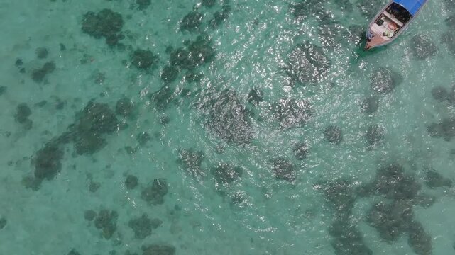Aerial drone view of Koh Lipe island, Satun, Thailand. Turquoise sea, coral reefs, white sand beaches and traditional long-tail boats in the Andaman Sea.