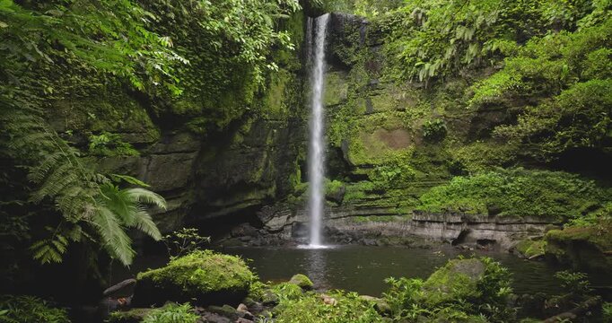 Tenaru Falls waterfall cascading into a natural pool surrounded by dense tropical rainforest and vibrant green vegetation, showcasing the untouched nature beauty of the Solomon Islands wilderness