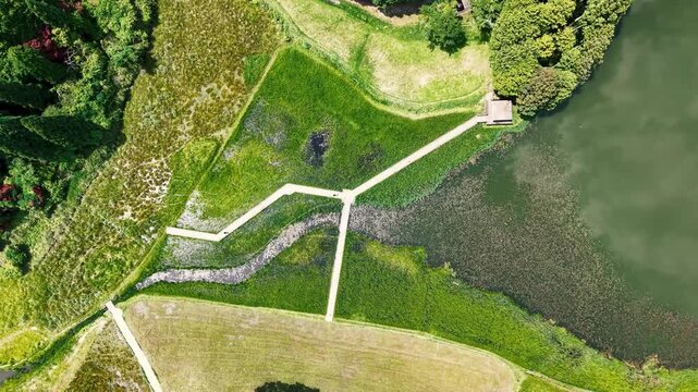 ドローンで真上から撮影した美しい湿原の木道と池の俯瞰風景
