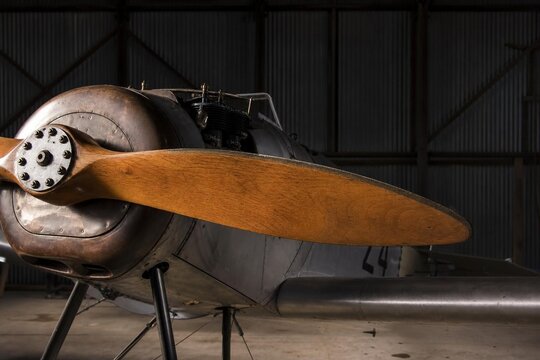 monoplane. The wooden propeller of a vintage monoplane in a quiet hangar. mobility guides, transit brochures, designed for mobility and urban transit guides, improves user orientation.
