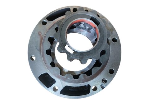Gerotor internal gear set inside its circular flange housing for automotive or industrial oil pump isolated on black background.