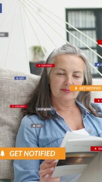 Vertical video: Woman reading book seeing alert banner social badges animating around her fading