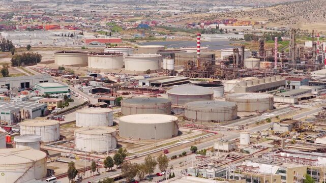Large industrial petrochemical plant featuring an oil refinery complex with storage tanks and pipelines, highlighting the concepts of energy production, fossil fuels, and industrial pollution