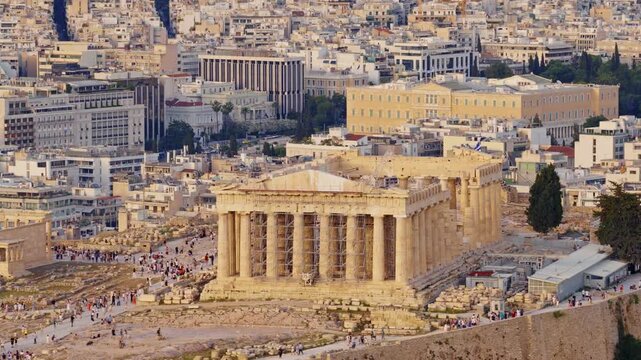 Aerial view of the ancient parthenon on the acropolis, a historic landmark surrounded by the sprawling cityscape of athens, greece, beautifully illuminated by the warm light of the setting sun