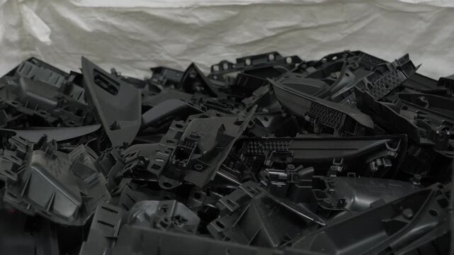 Pile of black plastic automotive scrap parts collected for recycling