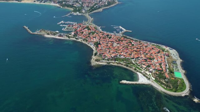 Historic Nessebar rises from the Black Sea as a drone smoothly reveals the rugged coastline and rooftops of the old town in Bulgaria.