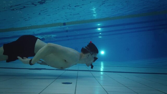 Freediver Gliding Along Pool Bottom