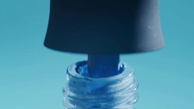 4K Video macro close up of pulling brush out from turquoise blue nail polish bottle, lacquer dripping slowly into container on plain pastel background, professional manicure salon aesthetic, cosmetic 