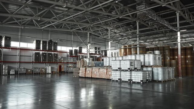 Industrial Warehouse Scene. Logistics Manager Reviews Inventory Amidst Reflective Concrete Floor Environment
