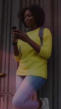 Vertical video: Woman leaning on metal wall, phone pinging, scrolling as icons animating, laughing