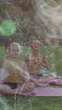 Vertical video: Kids on cue breathing bringing hands to prayer on mats green flare drifting calming