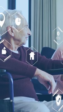 Vertical video: Aid tapping senior watch, senior checking wrist while hex icons drifting for health