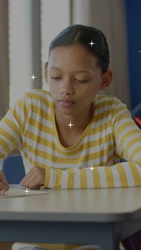 Vertical video: Schoolgirl writing with green pencil, pausing, looking up, stars around, smiling