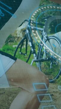 Vertical video: Cyclist stopping bike leaning on low wall stretching after ride with HUD overlaid