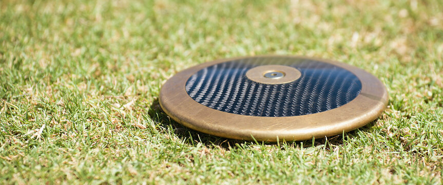 Close up of discuses on grass after impact on grass. Discus throw