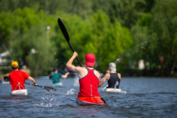 Rear view athletes kayakers paddling on open water © Real Sports Photos
