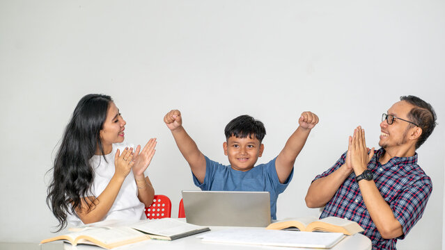 Proud Asian Parents Applauding Son Cheering with Raised Arms in Front of Laptop