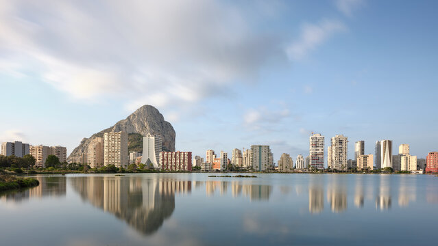Calpe skyline reflected in Salines de Calp with Penon de Ifach in the background, showing a calm Mediterranean travel destination.