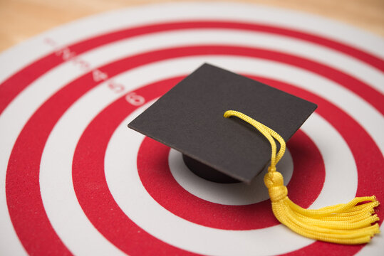 Closeup mortarboard is in the center of dartboard. Achieve target in the education, graduated from university, high score or pass the examination, honor, get a scholarship, get the good job concept.