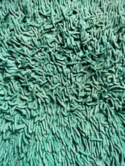 Full frame top view of a green shag microfibril bath mat or carpet texture with soft noodle fabric loops