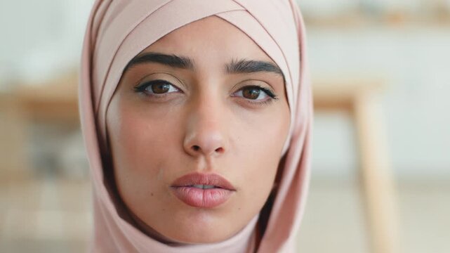 Sad stressed Arabian Muslim woman in hijab talking at camera indoors worried upset female Islamic girl portrait online video call conference virtual communication businesswoman interview indoor home