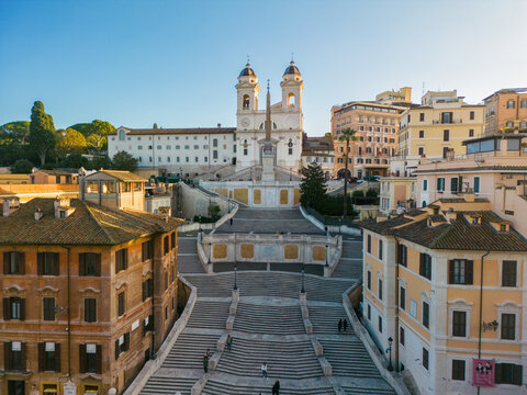Aerial view of the Spanish Steps and the Trinita dei Monti church surrounded by historic buildings and urban architecture in Rome, Lazio, Italy.