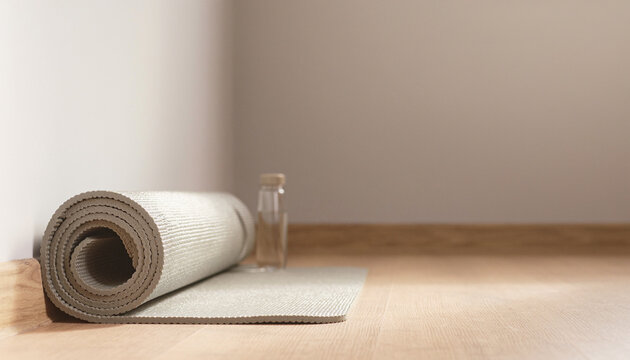 Rolled Yoga Mat on Wooden Floor with Copy Space