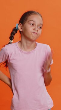 Face palm. Shame on you. Upset sad young preteen child girl kid making face palm gesture, feeling bored, disappointed in result, bad news, disagreement, quarrel. Teenager children on orange background