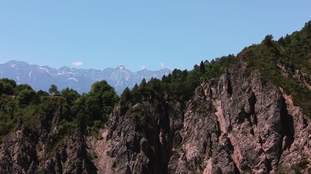 Steep dolomites mountainside in Friuli on a clear summer day. Majestic mountain cliffs tracking shot