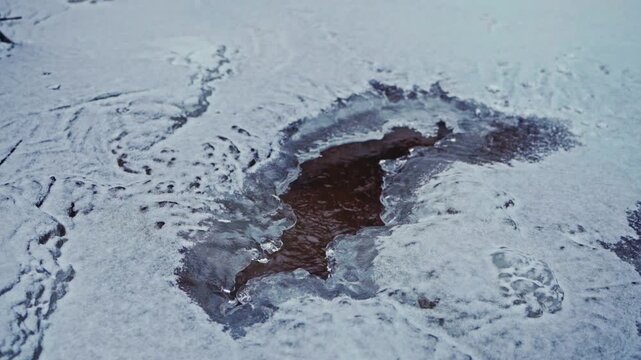 Irregular Hole In A Frozen Lake Surrounded By Snow. Close-up Shot