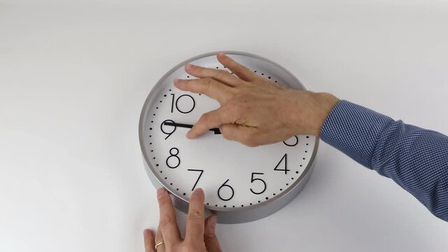 Moving clock hands from 2 o'clock to 3 o'clock, man's hand moves large format clock hands, with copy space.