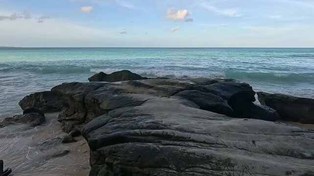Secluded Tropical Shoreline with Massive Dark Rocks and Turquoise Sea