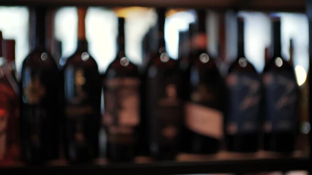 Row of wine bottles on shelf motion blur background cinematic background for commercial use.
