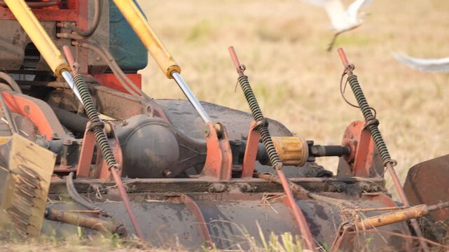 Agriculture machine harvester field farm crop metal wheel soil grass, tractor implement with tine spring machinery attachment on rural farmland operation